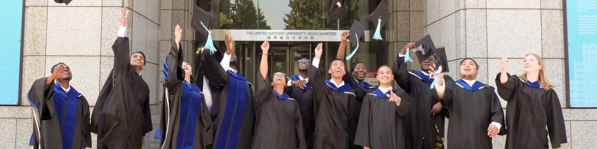 Graduating students outside throwing hats in air